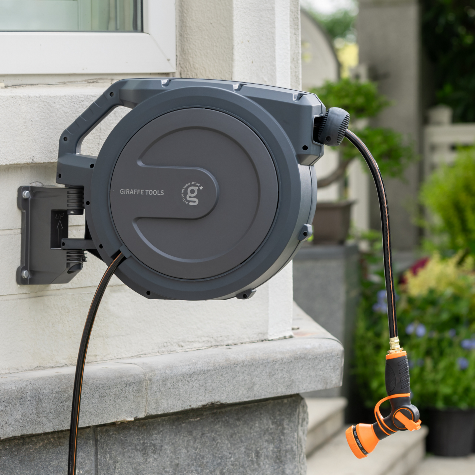 Giraffe Tools Retractable Garden Hose Reel-1/2in-100ft Features a wall-mounted hose reel with nozzle for neat garden watering.