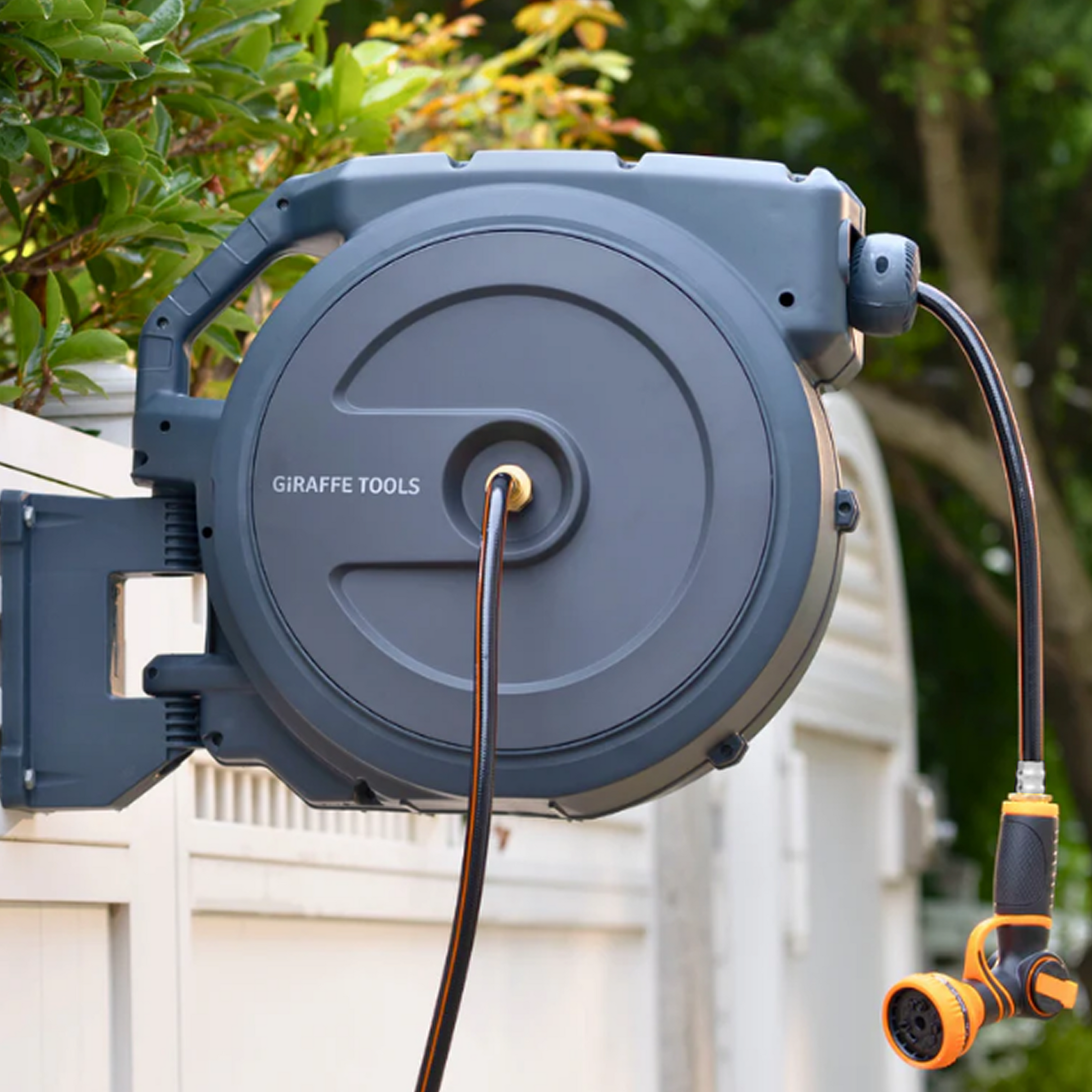 Giraffe Tools Retractable Garden Hose Reel-5/8in-90ft Features a wall-mounted hose reel with nozzle for neat garden watering.