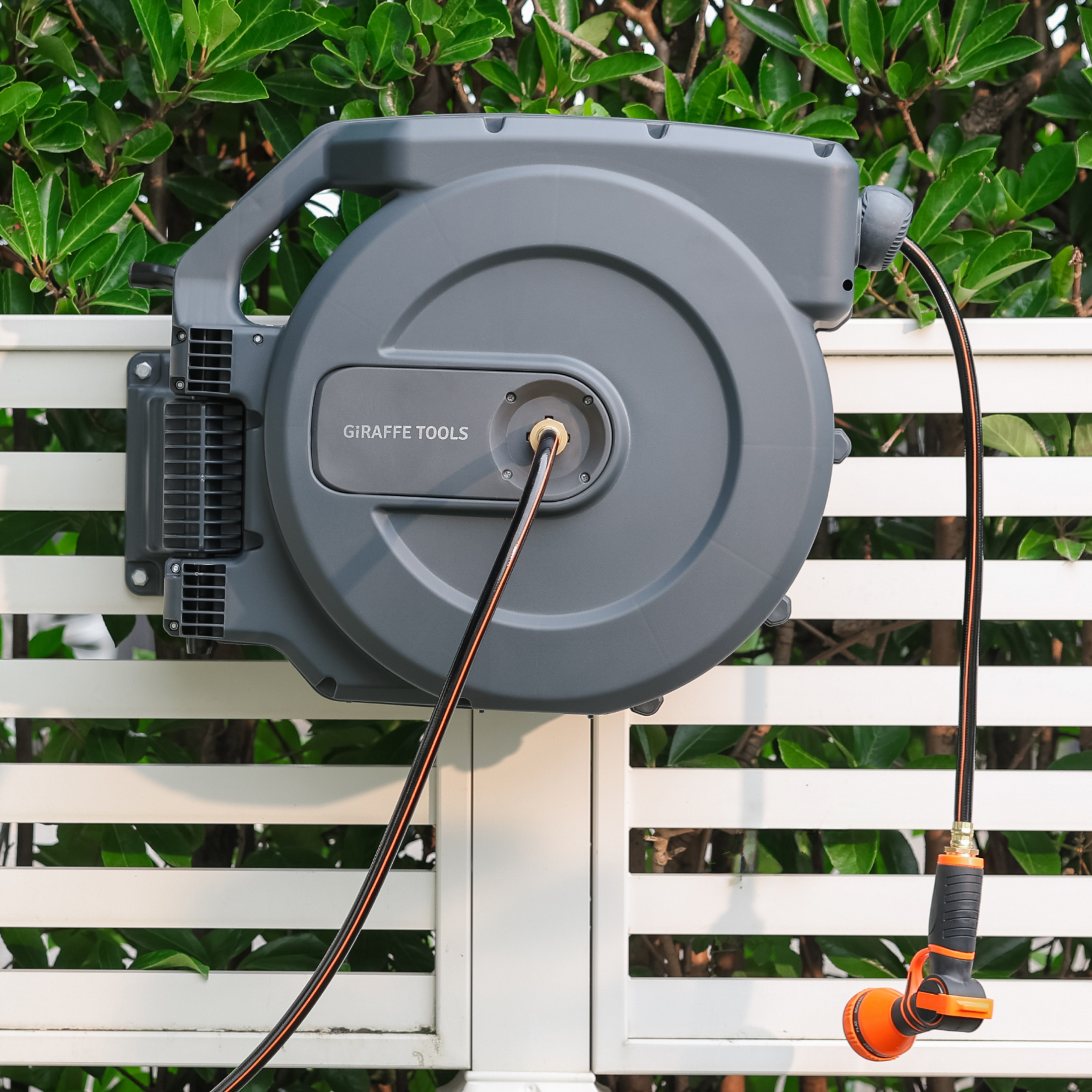 Giraffe Tools Retractable Garden Hose Reel-5/8 in-115ft Features a wall-mounted hose reel with nozzle for neat garden watering.