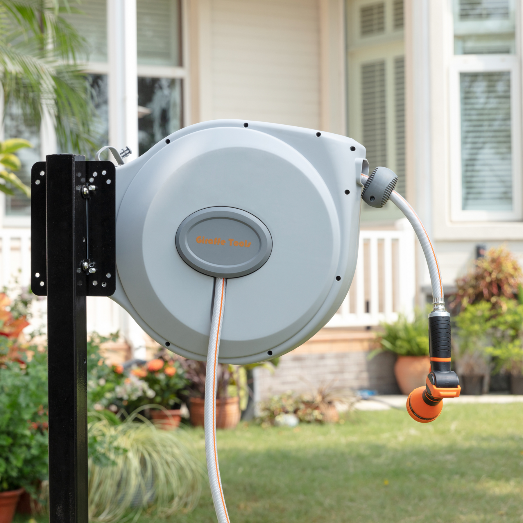 Giraffe Tools Retractable Garden Hose Reel-5/8 in-65ft Features a wall-mounted hose reel with nozzle for neat garden watering.