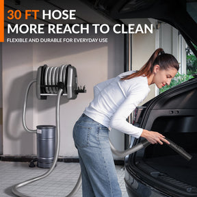 Woman using the 30 ft vacuum hose to clean a car trunk.